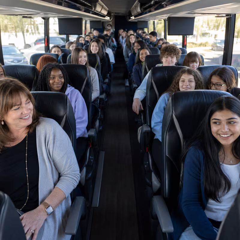 Group boarding a white charter bus for School Transportation transportation in Sunnyvale